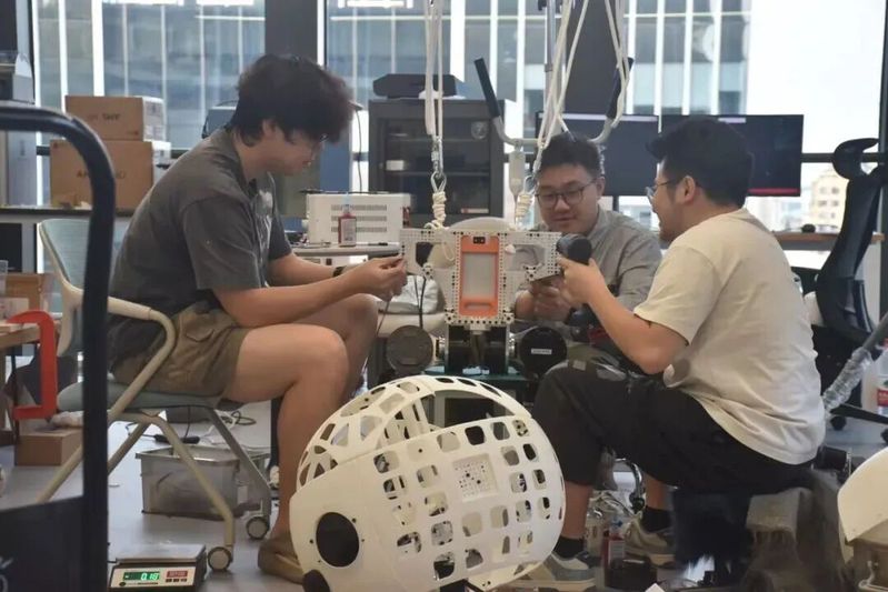学院博士生们正在打造自己设计的机器人。资料图片